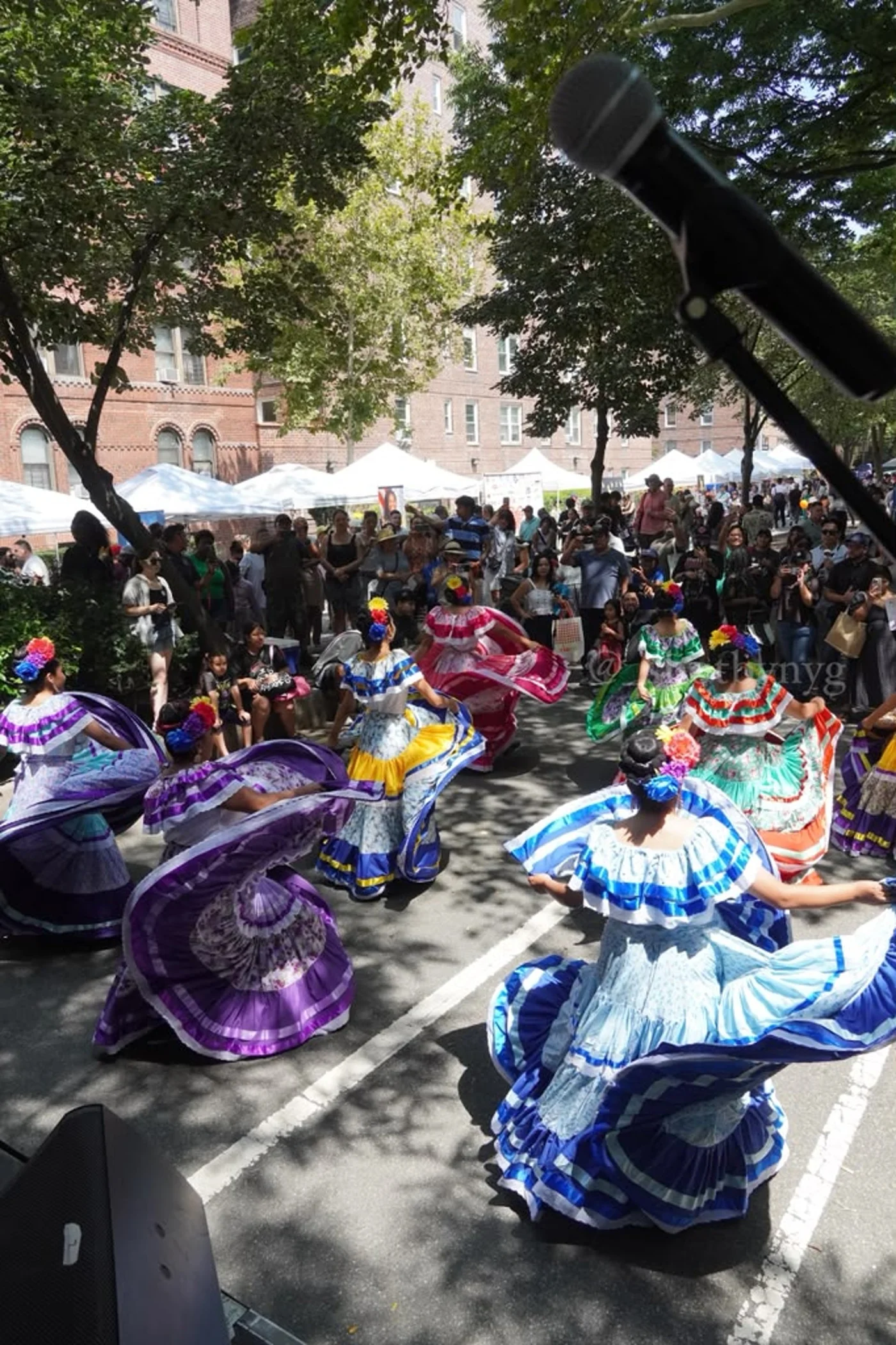 Dancers swirl colorful skirts as neighbors watch on 34th Avenue